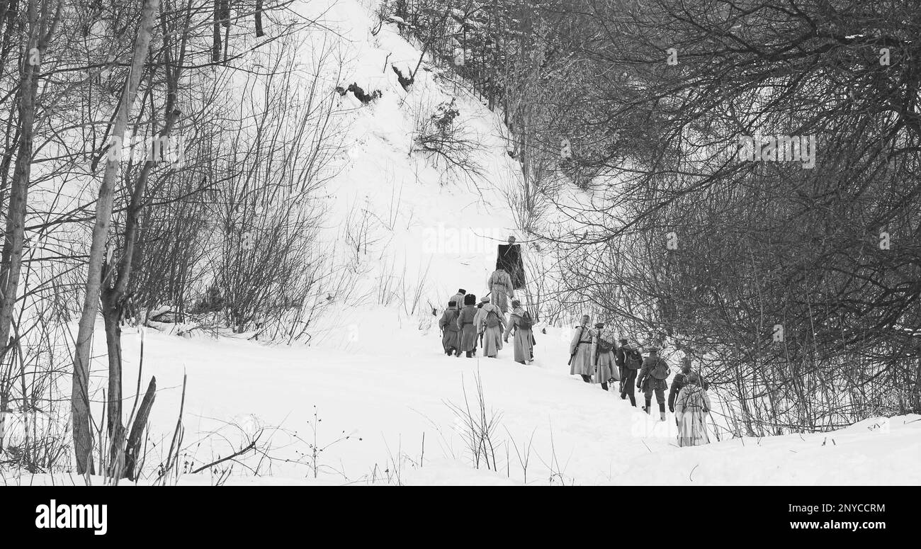 Men Dressed As White Guard Soldiers Of Imperial Russian Army In Russian Civil War s Marching Through Snowy Winter Forest. Historical Reenactment Stock Photo