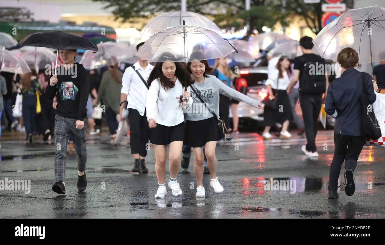 People walk scramble crossing with umbrella in Shibuya Ward, Tokyo on ...