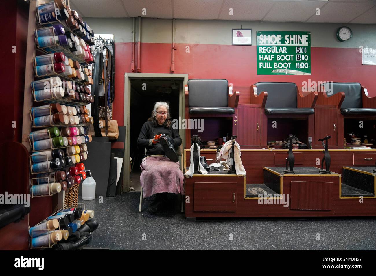 Bertha Gomez shines a shoe while waiting for customers at the Alpha