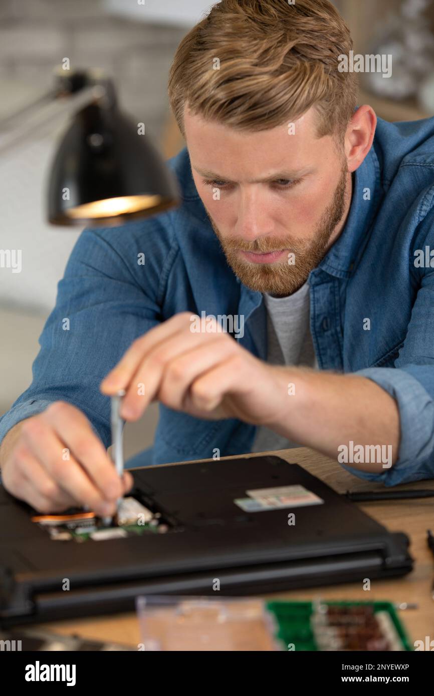man disassembles laptop disposal of dangerous battery power Stock Photo