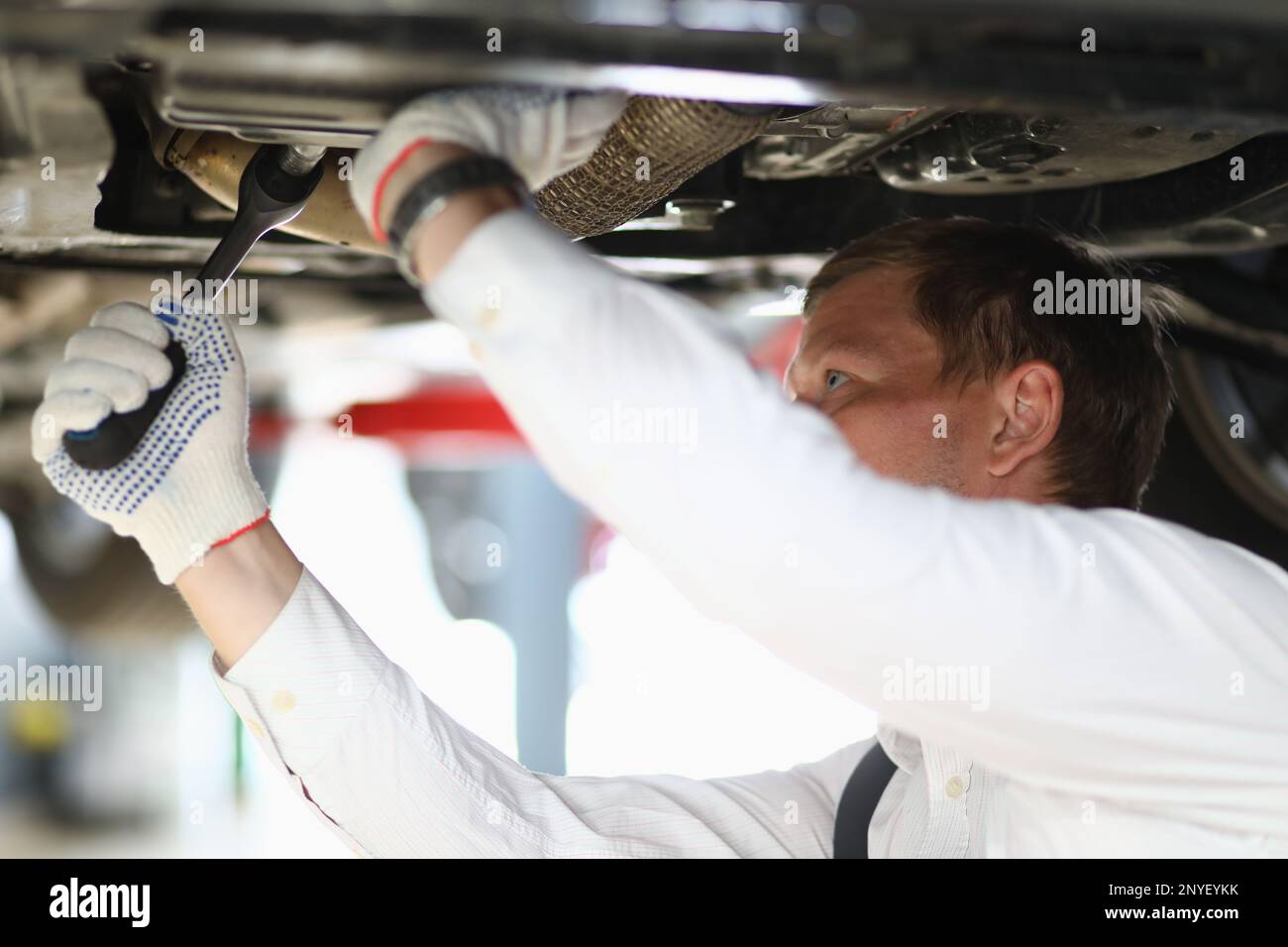Auto mechanic checks running gear of car at service station Stock Photo ...