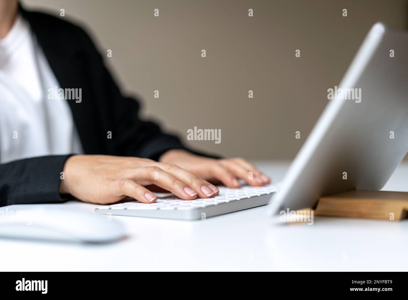 Female business person using wireless keyboard and digital tablet. Stock Photo