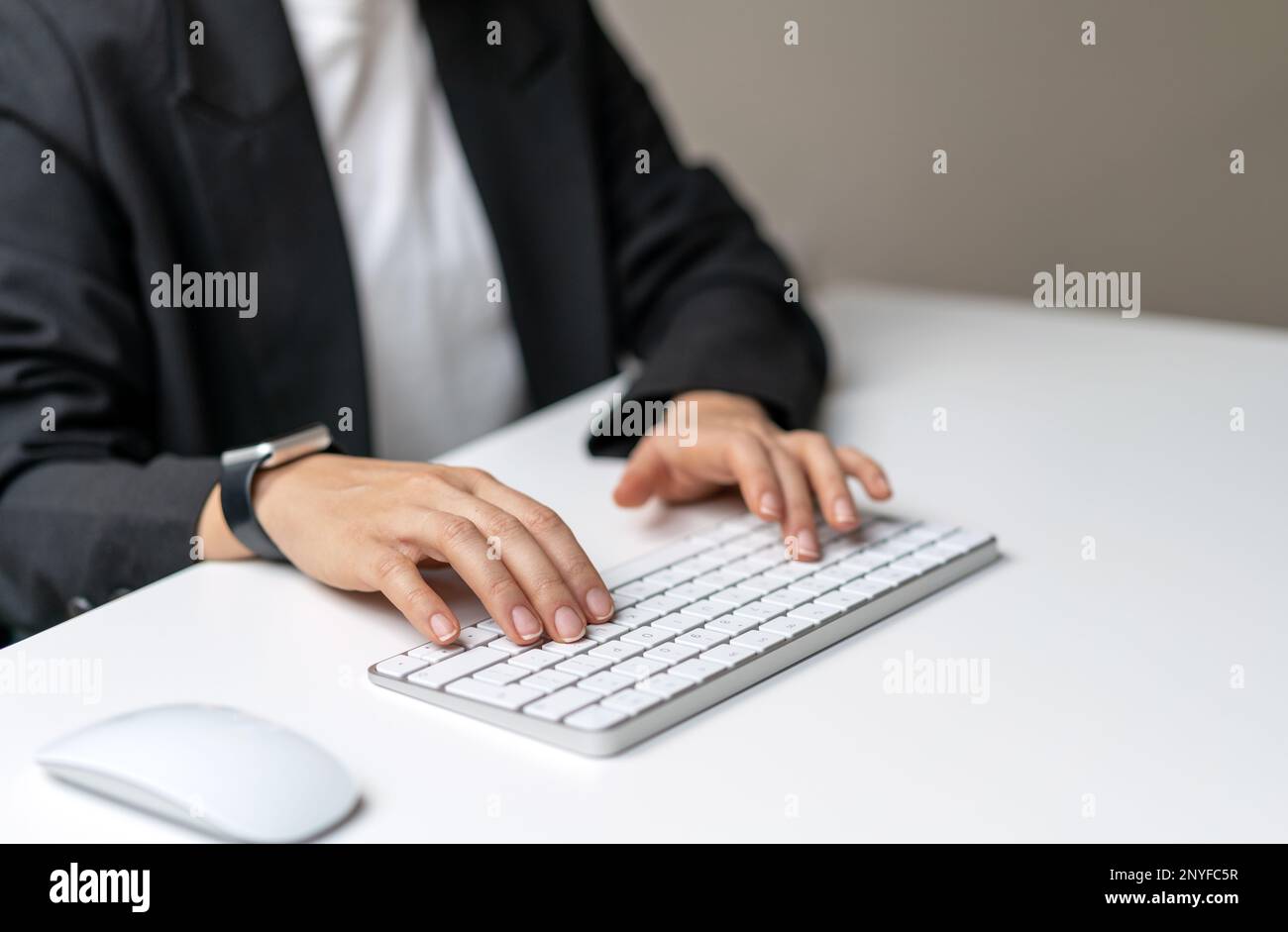 Female hands typing on wireless computer keyboard. Stock Photo