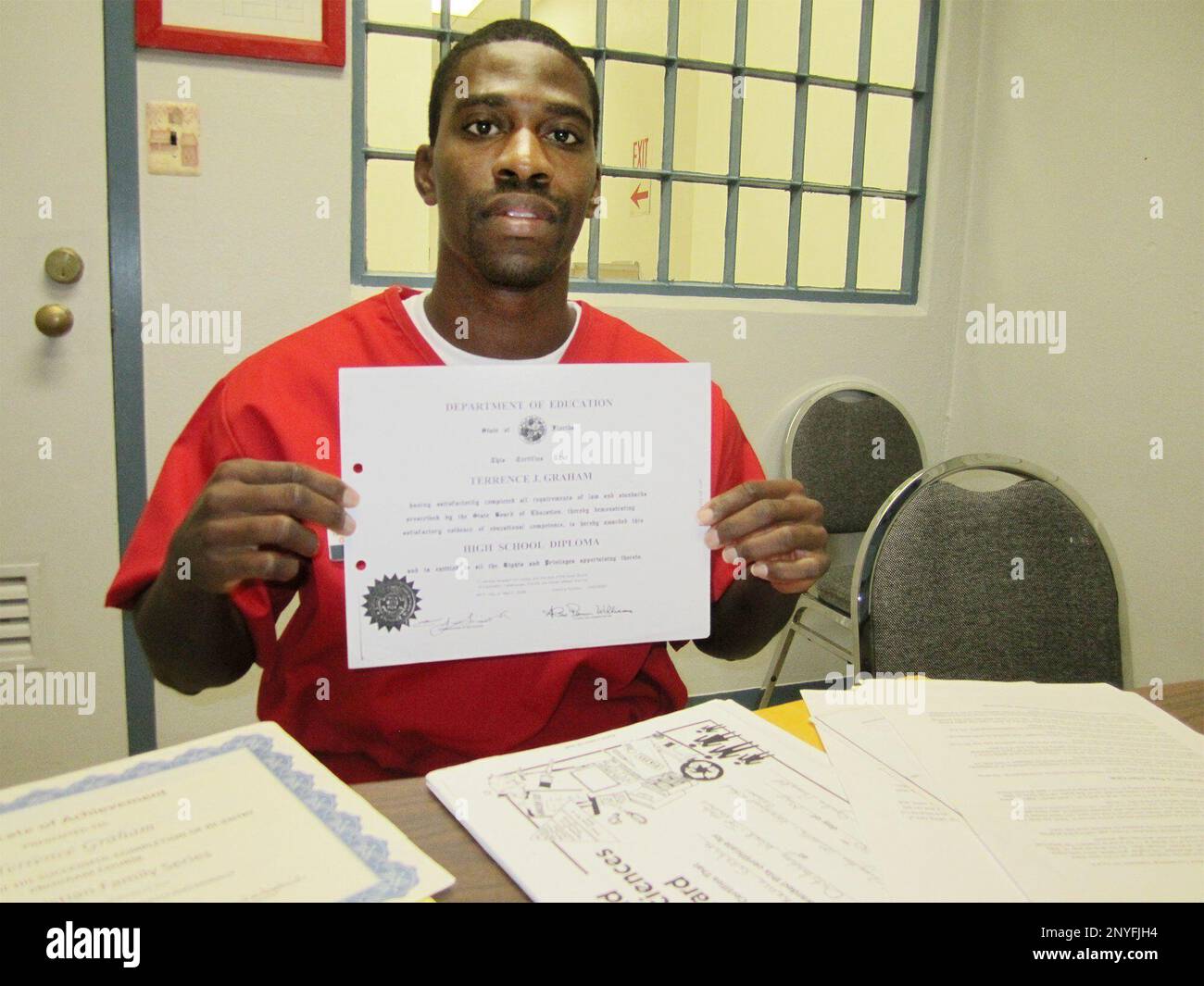 In this December 2016 photo, Terrance Graham holds the high school diploma he earned while he was incarcerated in Florida State Prison at Raiford, Fla. At 16, Graham had been ordered to spend the rest of his life behind bars for a 2004 armed home invasion. Graham was on probation at the time after participating in an attempted restaurant robbery a year earlier. Graham had no option for freedom other than executive clemency. But the Supreme Court ruled that life without parole for a crime that doesn't involve murder is unconstitutional. Graham was ultimately resentenced to 25 years in prison, m Stock Photo