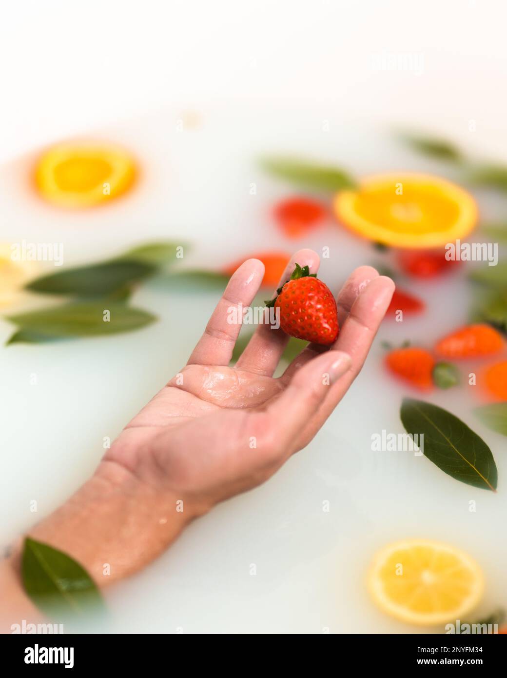 From above of crop anonymous female hand showing fresh strawberry while ...