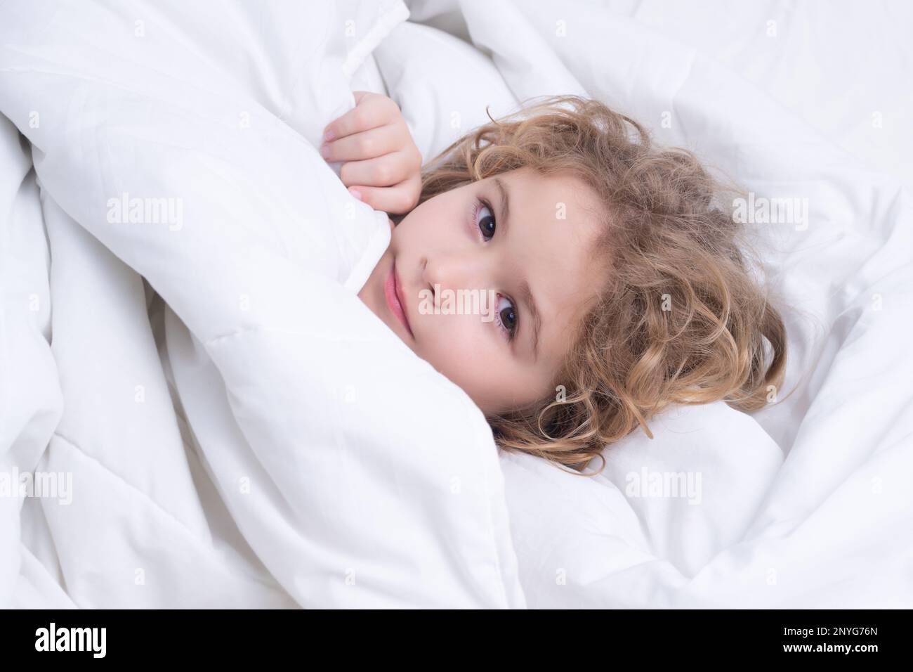 Kid under covers, face cover with blanket. Quietly sleeping. Portrait