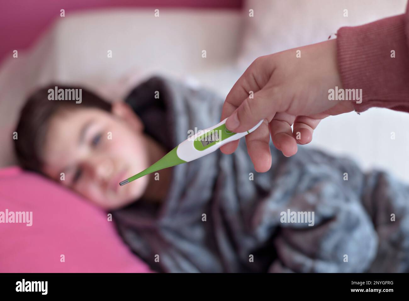 Closeup thermometer. Mother measuring temperature of her ill kid. Sick