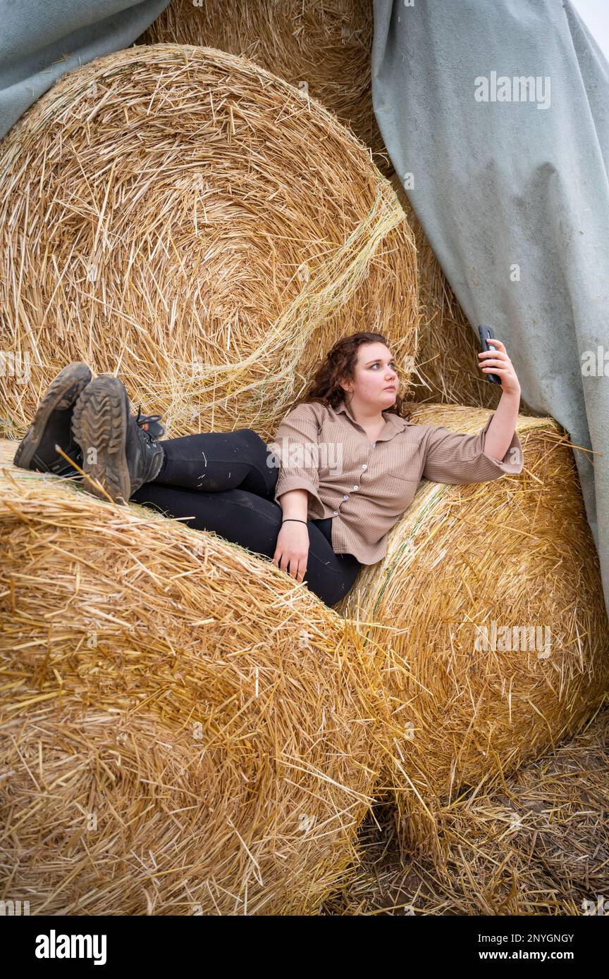 Young Woman with brown curly hair lying down on the top of two stacked ...