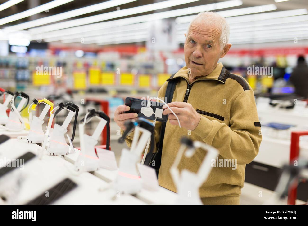 elderly grayhaired man pensioner examining counter with electronic