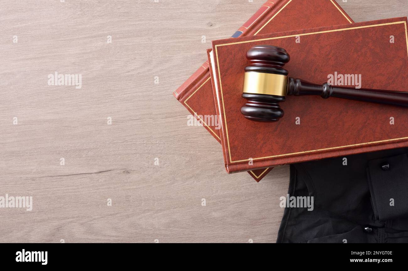 background with detail of gavel on lawbooks and toga on wooden table. Top view Stock Photo