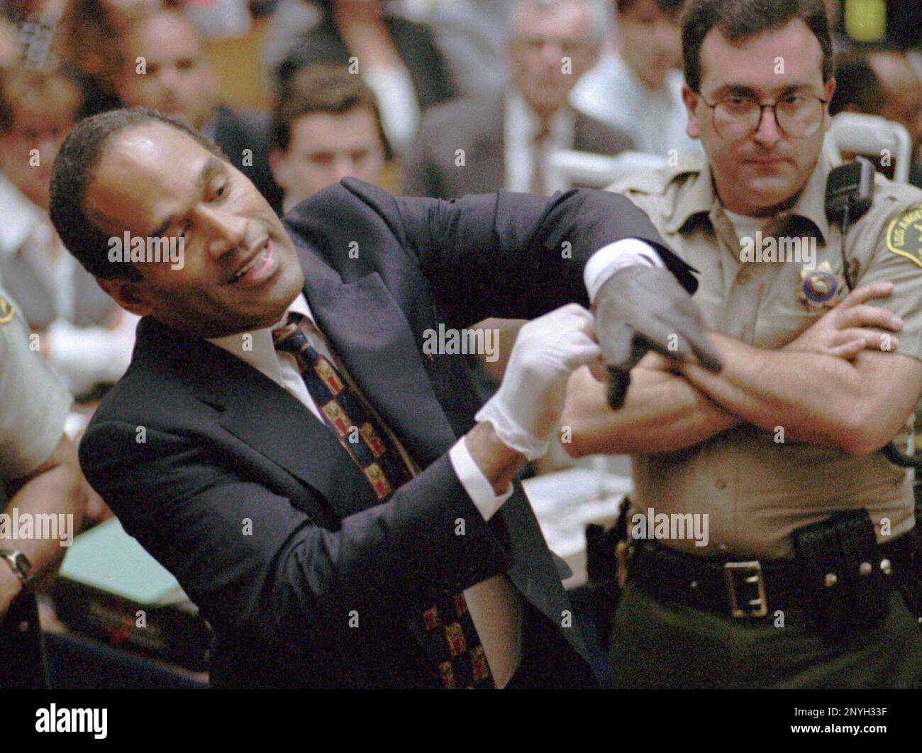 FILE - In this June 15, 1995 file photo, O.J. Simpson, left, grimaces as he tries on one of the leather gloves prosecutors say he wore the night his ex-wife Nicole Brown Simpson and Ron Goldman were murdered in a Los Angeles courtroom. Simpson, the former football star, TV pitchman and now Nevada prison inmate, will have a lot going for him when he appears before state parole board members Thursday, July 20, 2017, seeking his release after more than eight years for an ill-fated bid to retrieve sports memorabilia. (AP Photo/Sam Mircovich, Pool, file) Stock Photo