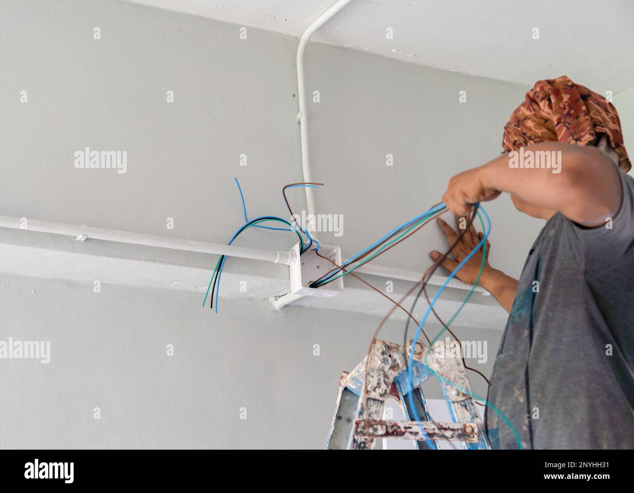 Technician pull wire from conduit in building site Stock Photo Alamy