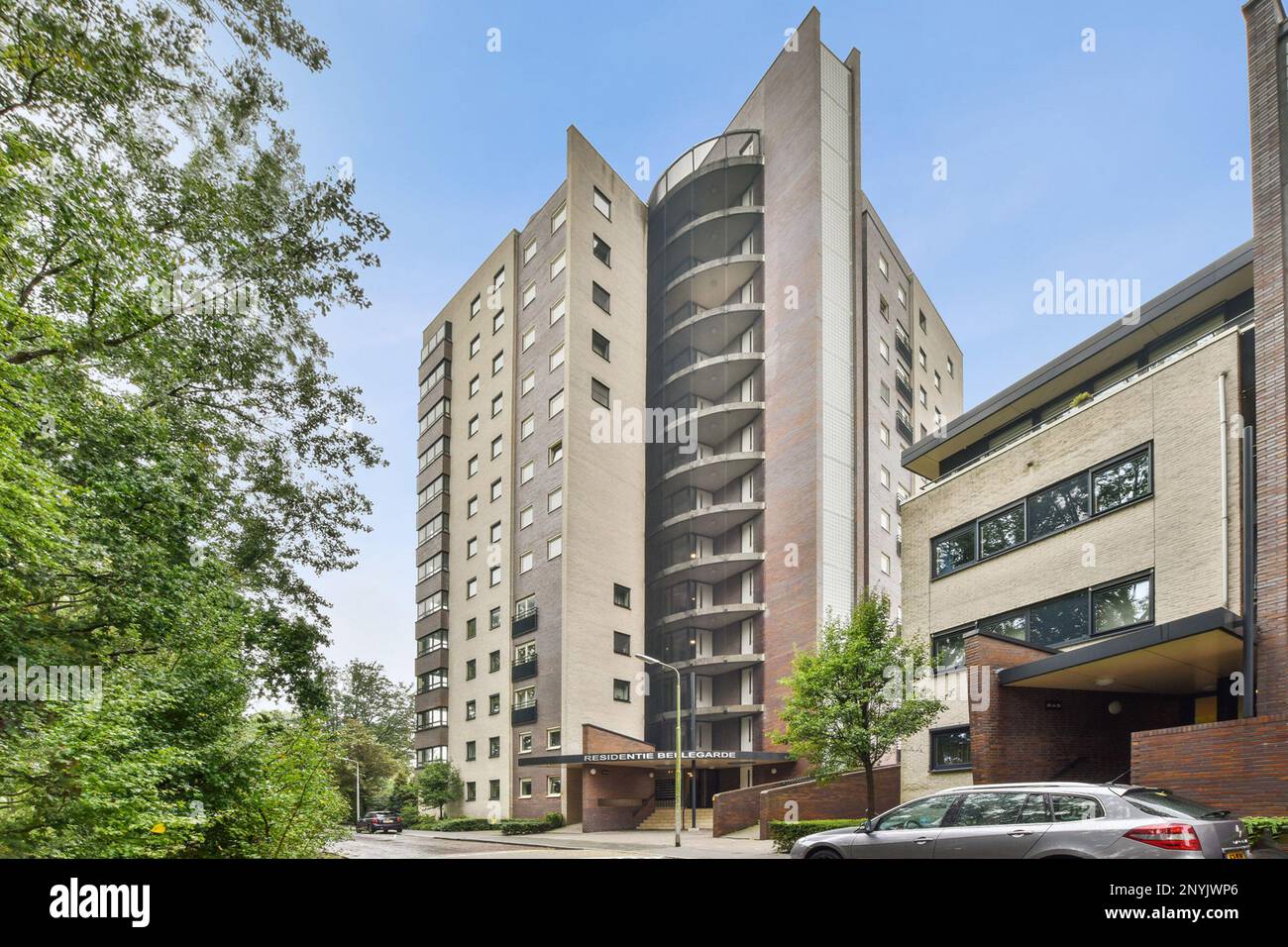 an apartment building on the corner of a street with cars parked in ...