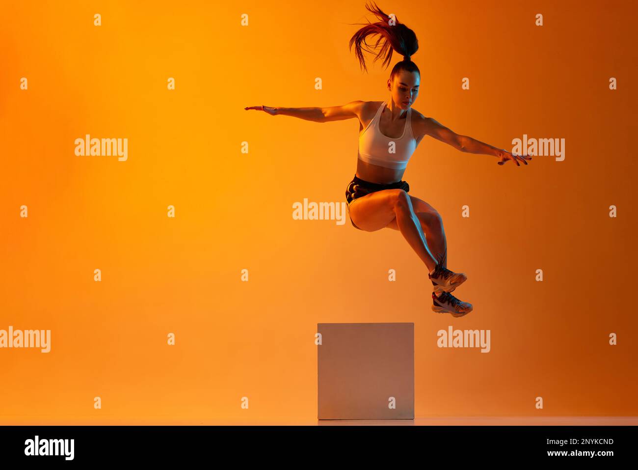 Muscular strong body. Young sportive girl, athlete training, jumping