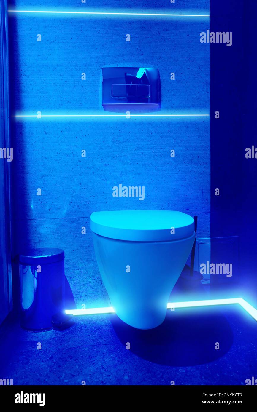 Toilet bowl in public restroom lit with UV blue light Stock Photo Alamy