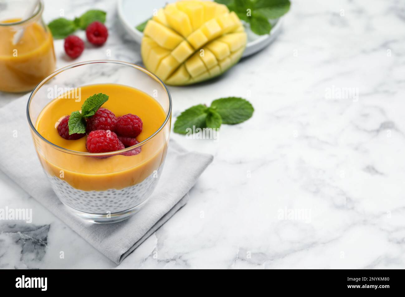 Delicious chia pudding with mango sauce and raspberries on white marble ...