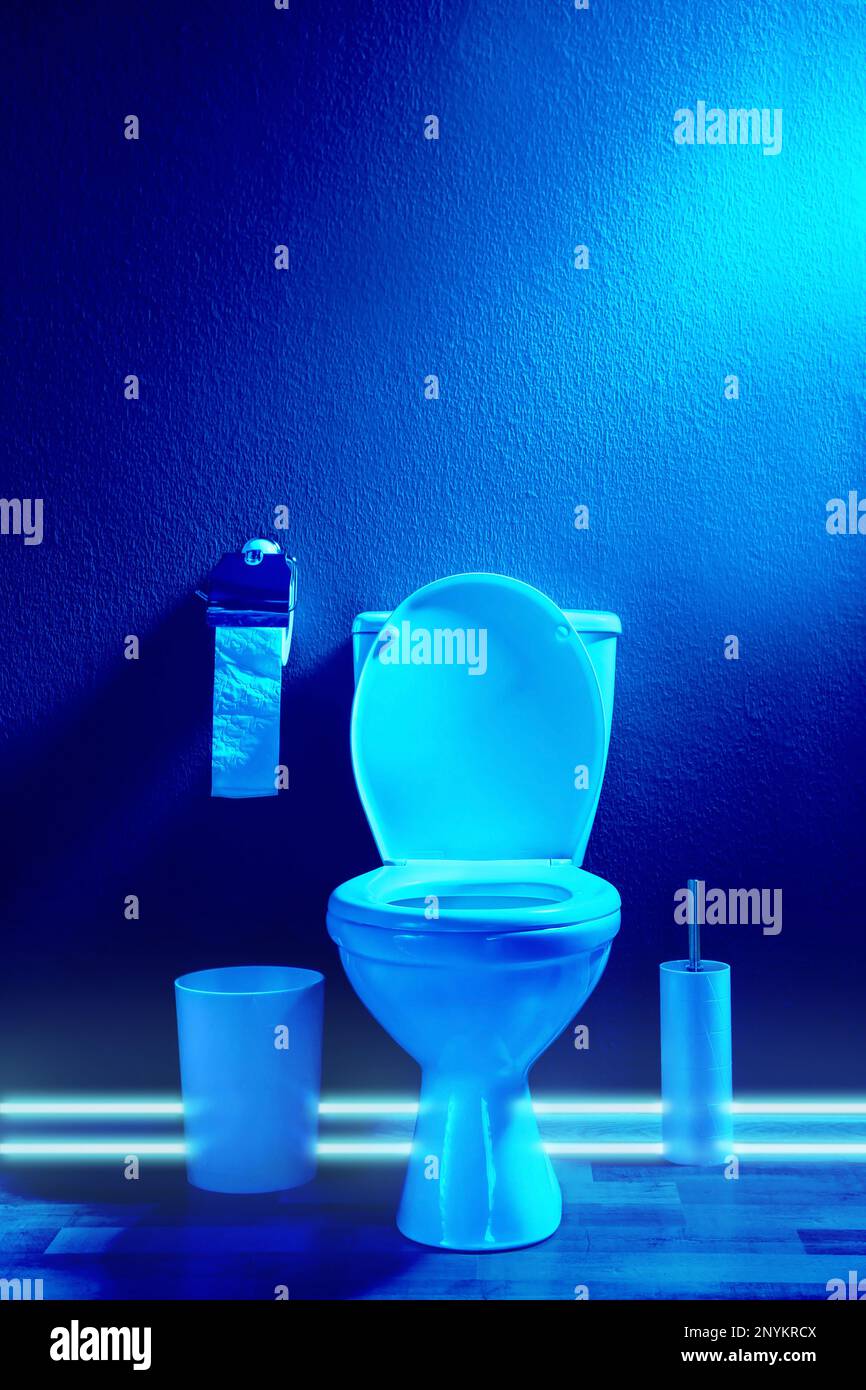 Toilet bowl in public restroom lit with UV blue light Stock Photo Alamy