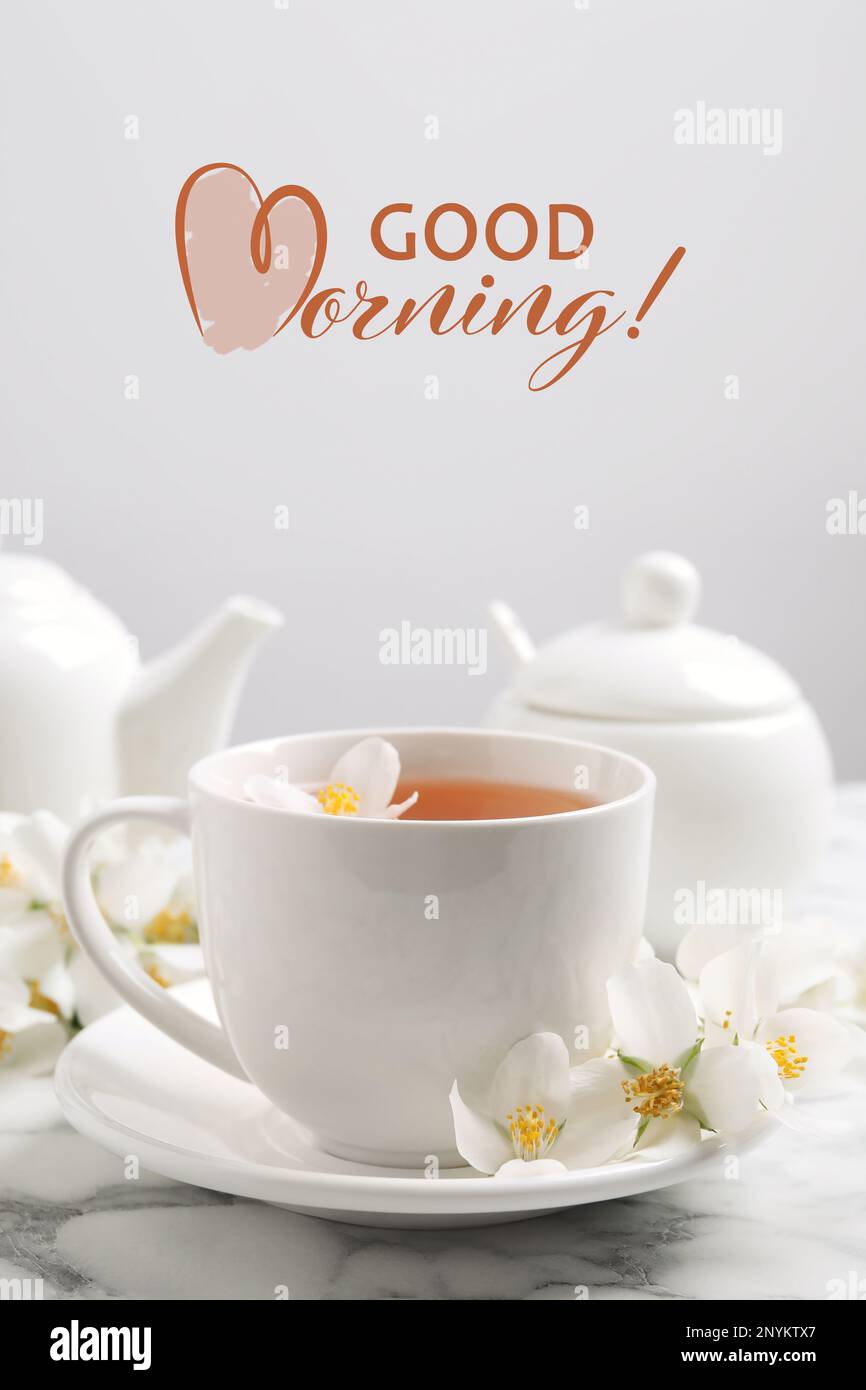 Aromatic jasmine tea and fresh flowers on white marble table. Good ...