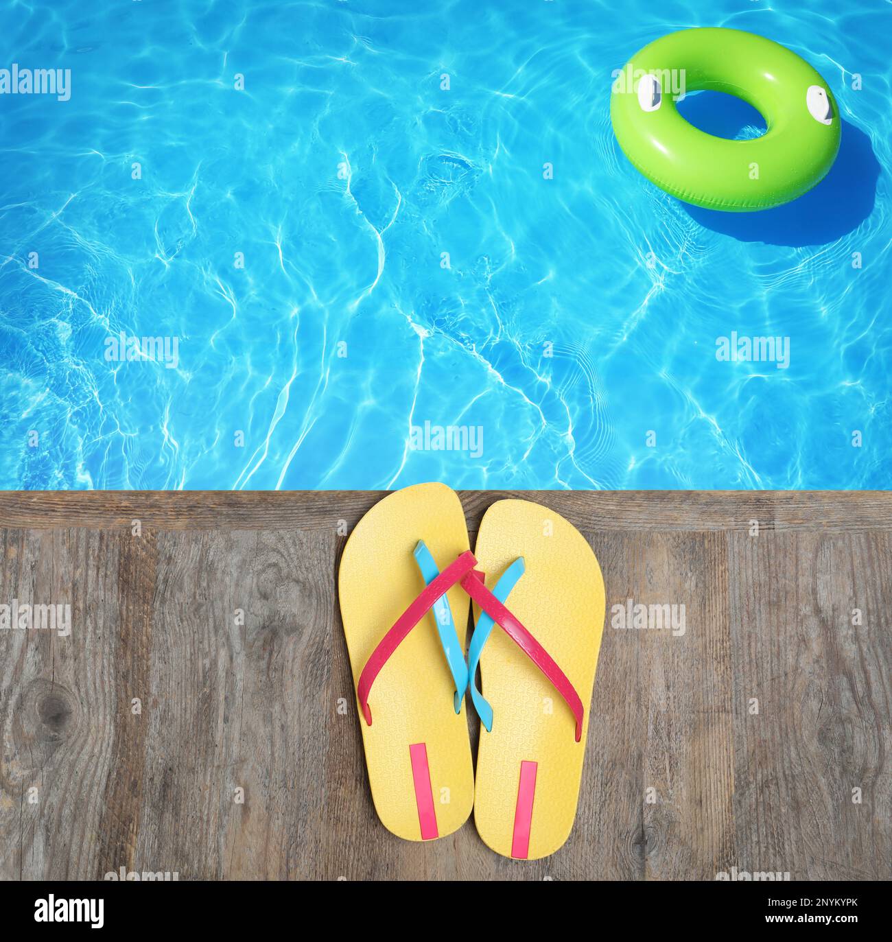 Pair of flip flops on wooden deck near swimming pool, top view Stock ...