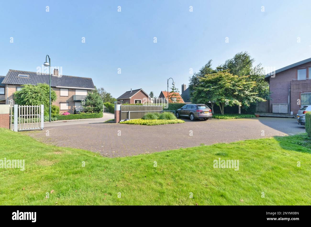 a house with a car parked in the driveway and two cars parked on the