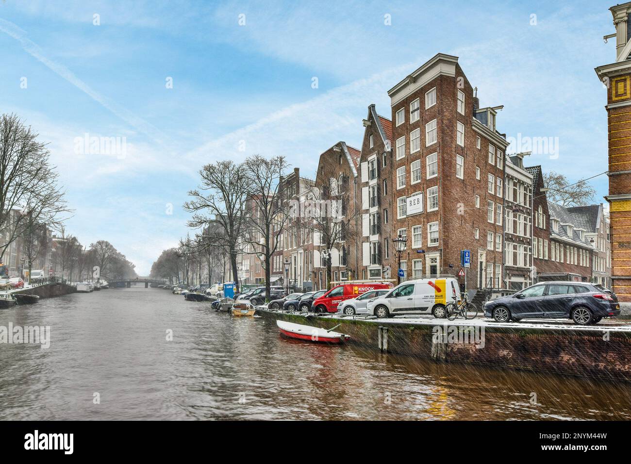 a flooded street with cars parked on the side and buildings in the ...