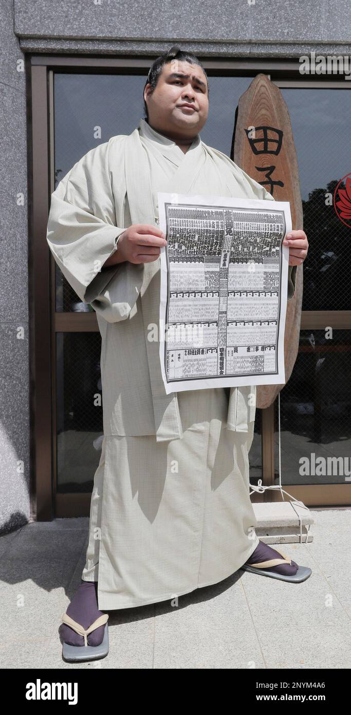 Newly ozeki promoted Takayasu poses with banzuke, the rankings list
