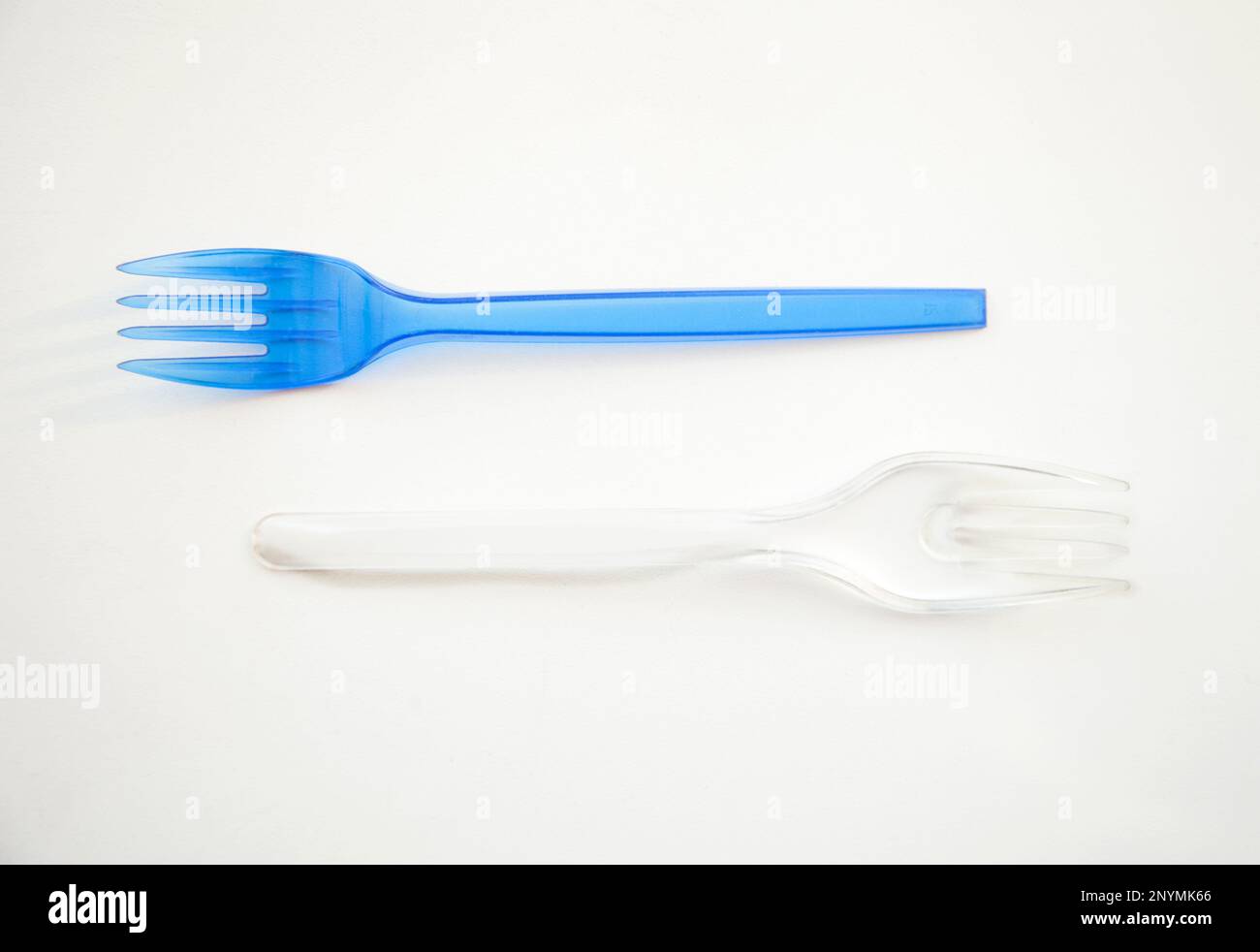 2 forks blue and transparent isolated on white. Plastic cutlery. Beautiful harmony food Yin Yang simple minimalism Stock Photo