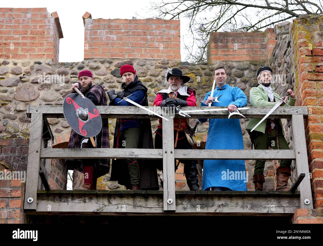 02 March 2023, Brandenburg, Bernau: Members of the Bernauer Briganten around Brigantenchef Bernd Eccarius-Otto (M) stand next to each other in the Lughaus of the city wall during a press appointment for the upcoming 25th International Swordsmen Meeting. In the Erich Wünsch Hall, about 130 swordsmen from 18 clubs and groups want to show their skills at the swordsmen's meeting on March 12, 2023. In authentic costumes and with short show interludes then among other things gladiator fights of the old Rome, the shield wall of the Wikinger, the Kendo of the Japanese Samurai, the Gatka of the Indian Stock Photo