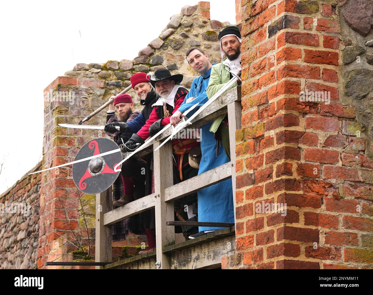 02 March 2023, Brandenburg, Bernau: Members of the Bernauer Briganten around Brigantenchef Bernd Eccarius-Otto (M) stand next to each other in the Lughaus of the city wall during a press appointment for the upcoming 25th International Swordsmen Meeting. In the Erich Wünsch Hall, about 130 swordsmen from 18 clubs and groups want to show their skills at the swordsmen's meeting on March 12, 2023. In authentic costumes and with short show interludes then among other things gladiator fights of the old Rome, the shield wall of the Wikinger, the Kendo of the Japanese Samurai, the Gatka of the Indian Stock Photo