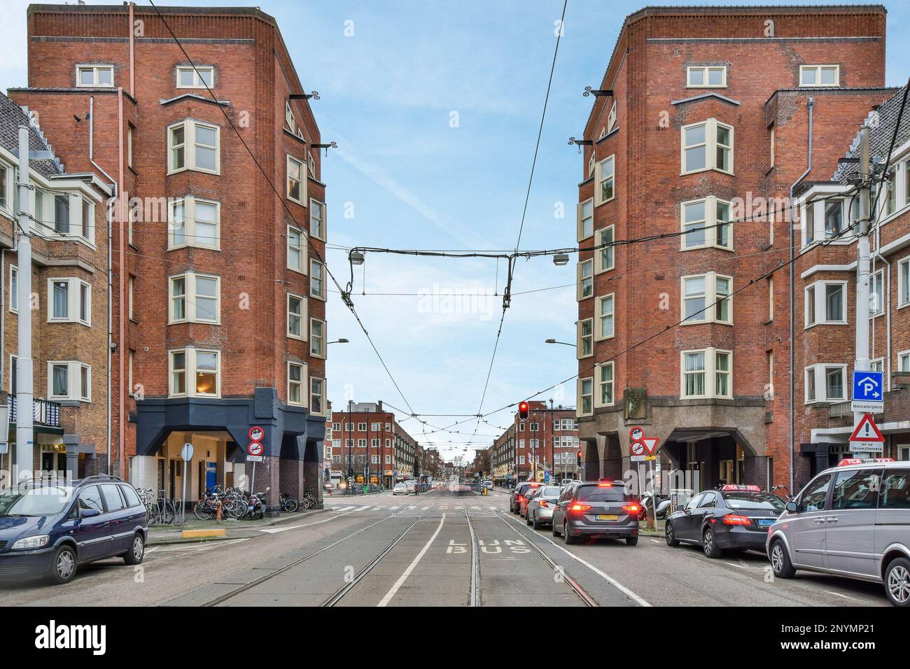a city street with cars parked on the side and buildings in the back ...