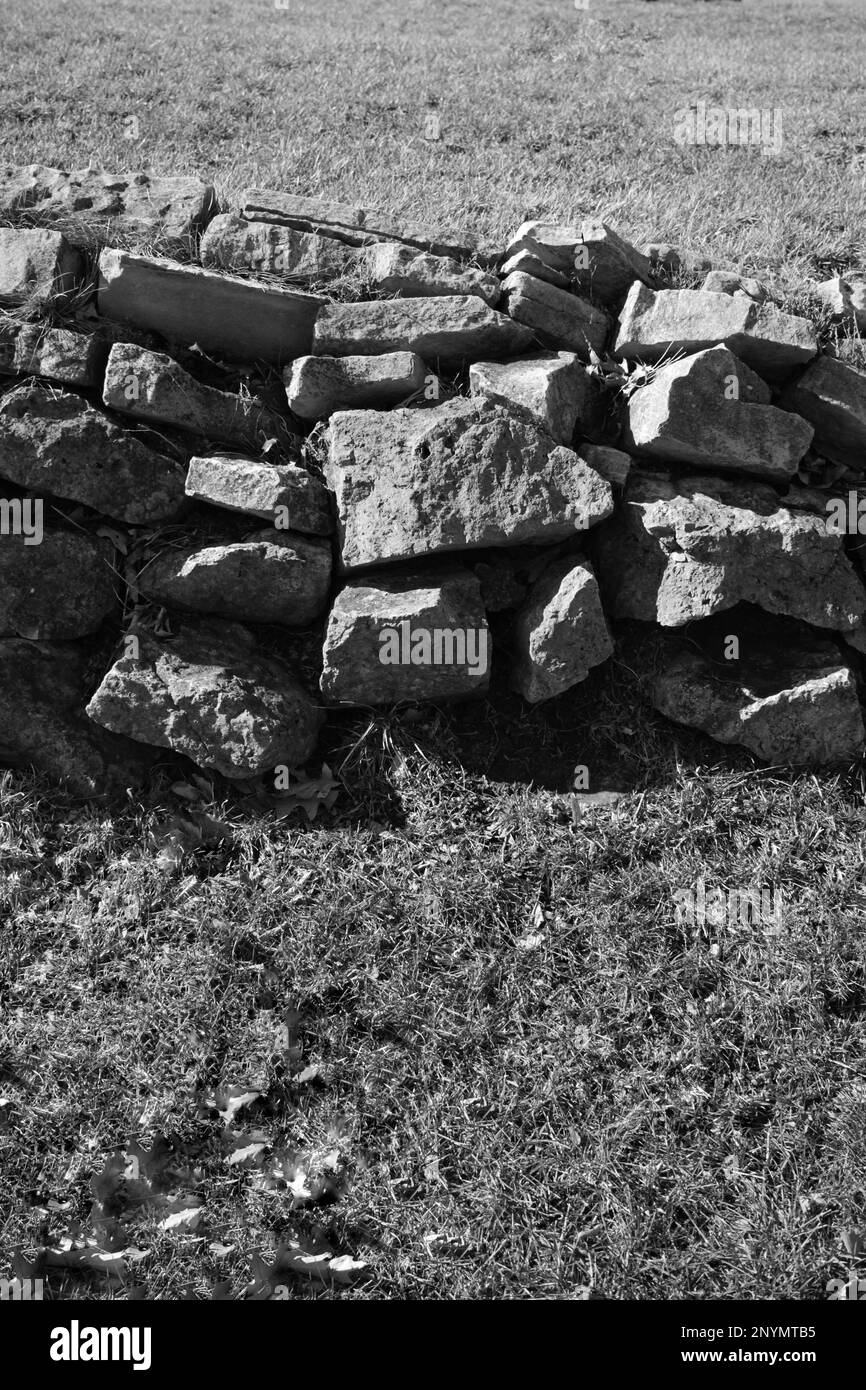 The ruins of an old stone wall on a country hill in a black and white ...