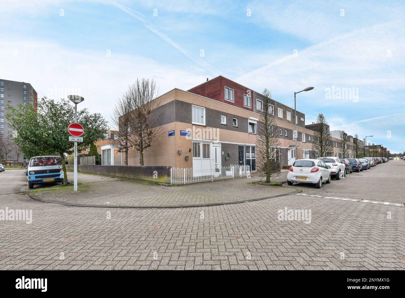 a street with cars parked on the side and buildings in the back ground ...