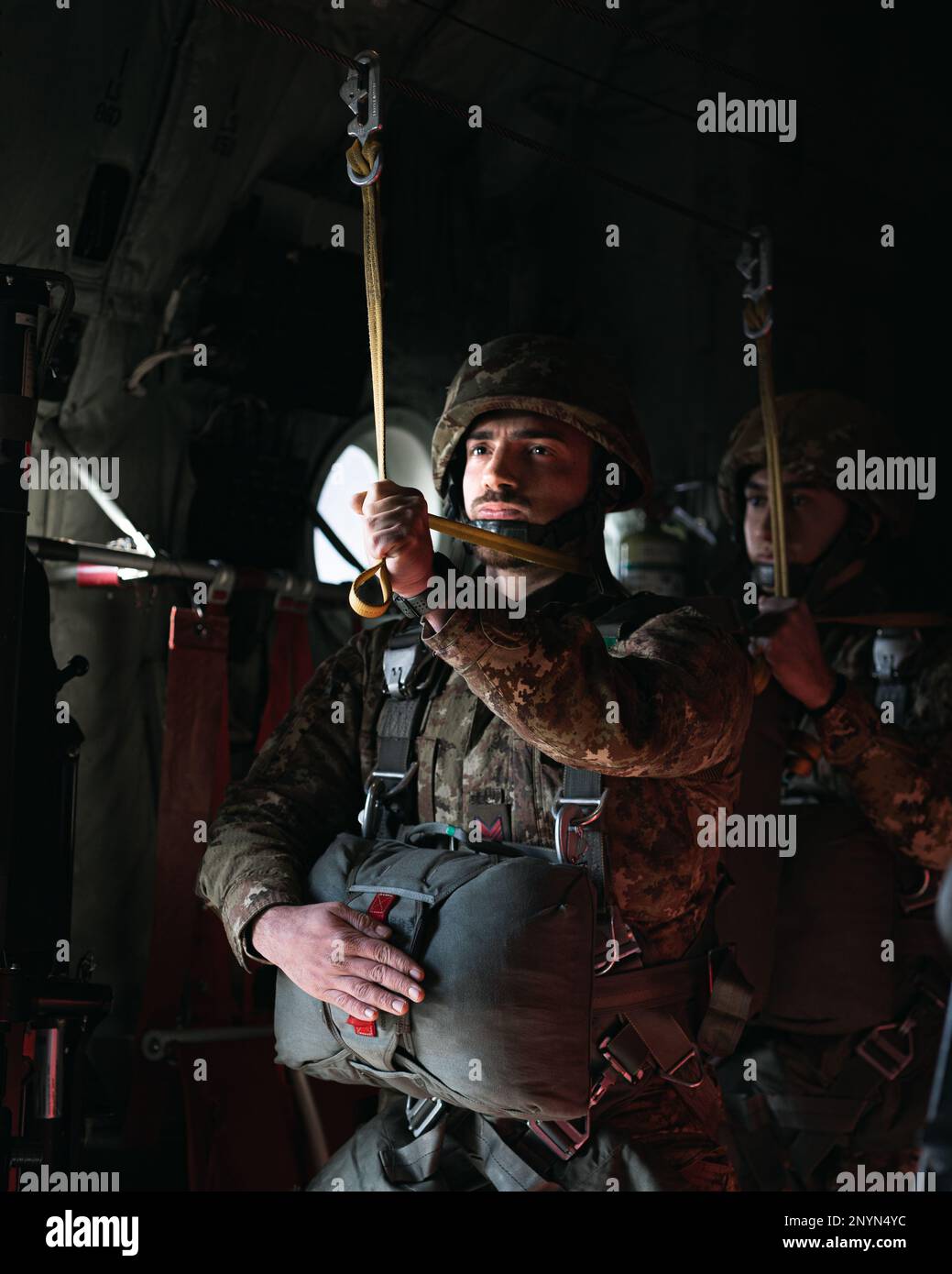 An Italian Army paratrooper with the Folgore Parachutist Brigade awaits jump commands in a C-130 Hercules aircraft during an airborne operation with U.S. Army paratroopers from the 173rd Airborne Brigade at Juliet Drop Zone, Pordenone, Italy, Jan. 26, 2023.    The 173rd Airborne Brigade is the U.S. Army's Contingency Response Force in Europe, providing rapidly deployable forces to the United States European, African, and Central Command areas of responsibility. Forward deployed across Italy and Germany, the brigade routinely trains alongside NATO allies and partners to build partnerships and s Stock Photo