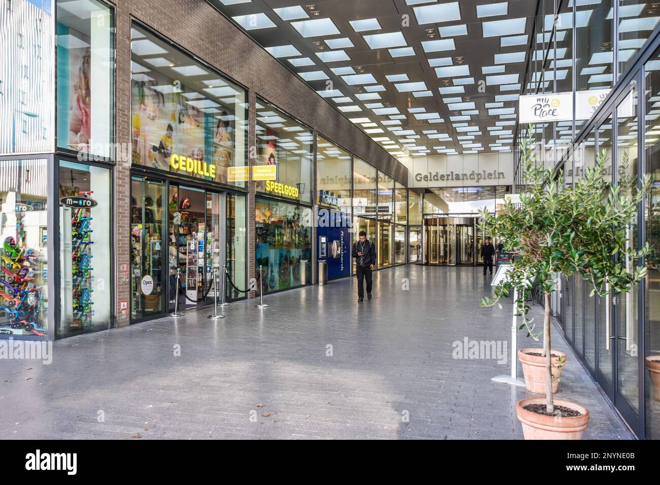 an empty shopping mall with people walking in the aisles and shops side of the street, all lined up against each other Stock Photo - Alamy