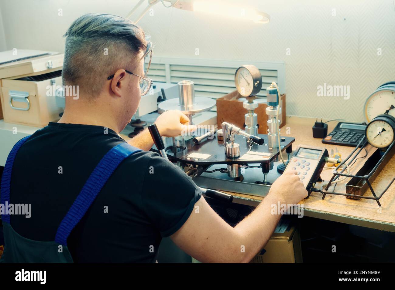 Professional calibration of pressure gauges and sensors. Working man is engaged in verification