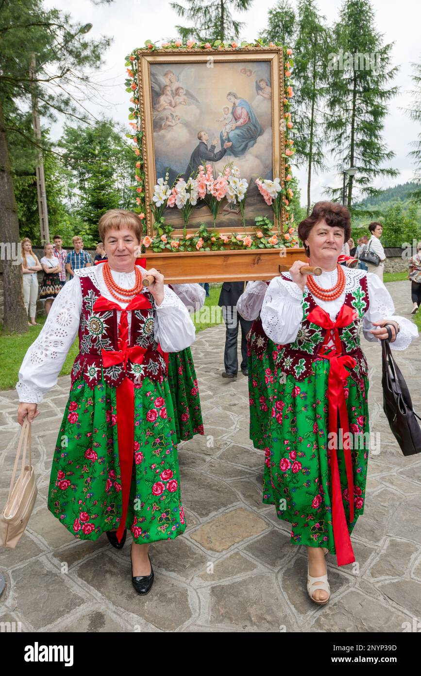 Women in traditional folk clothes, carrying holy painting, Corpus Christi celebration in Letownia, Gorals (Polish highlander people) village, Beskids mountain range, Western Carpathians, Malopolska region, Poland Stock Photo