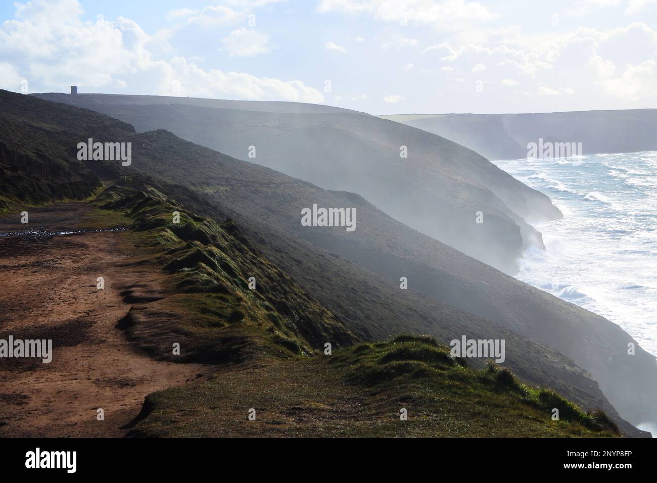 Spray rising over the cliffs between St. Agnes and Chapel Porth on the North Cornish coast near St. Agnes, Cornwall, UK - John Gollop Stock Photo