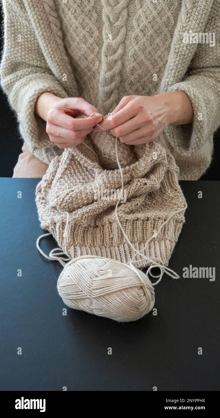 Female hands knitting in cose-up. Girl relaxing knitting a warm sweater. Stock Photo