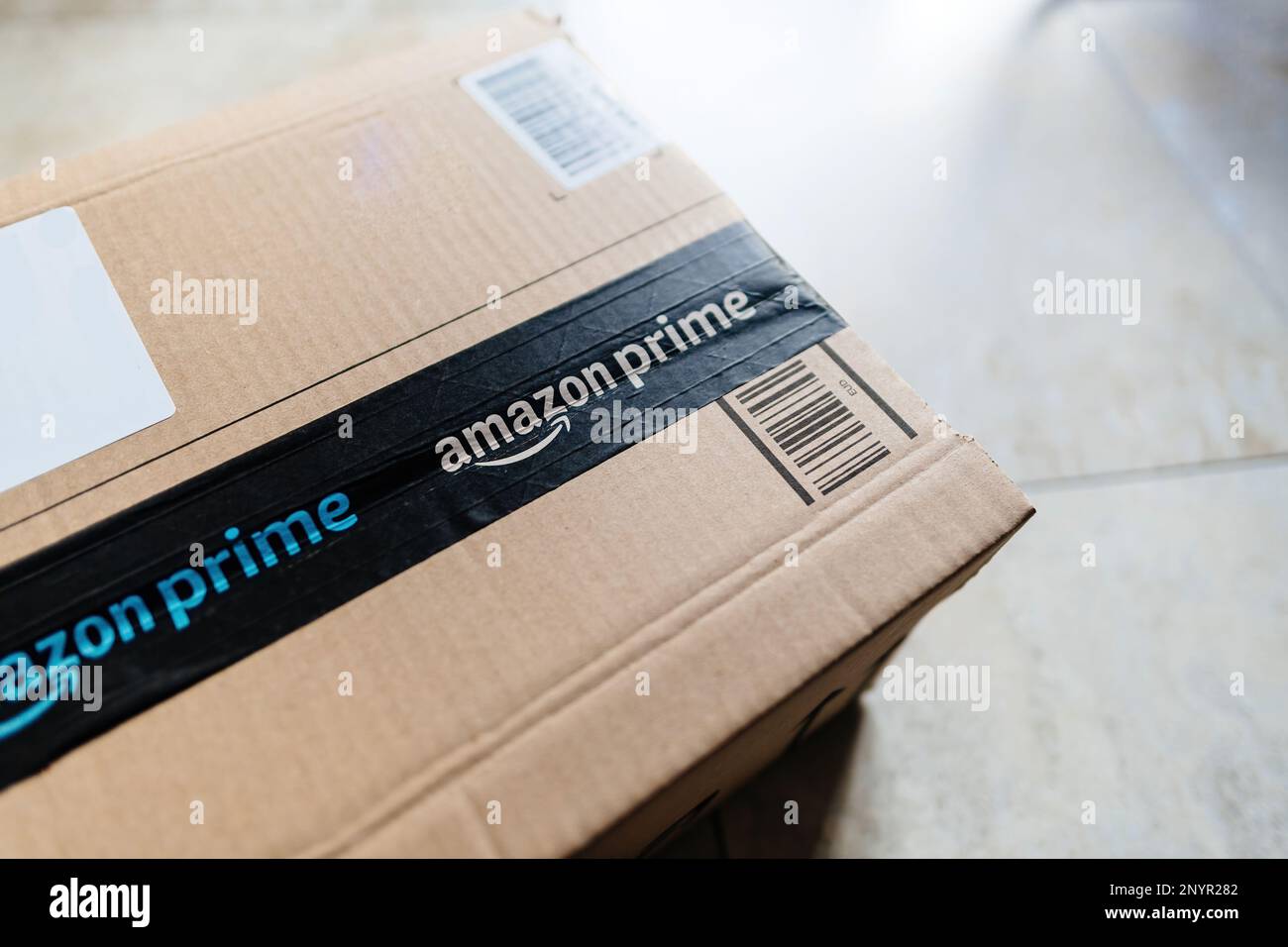 Paris, France - Mar 1, 2023: Amazon Prime cardboard parcel on the floor right before the unboxing unpacking Stock Photo
