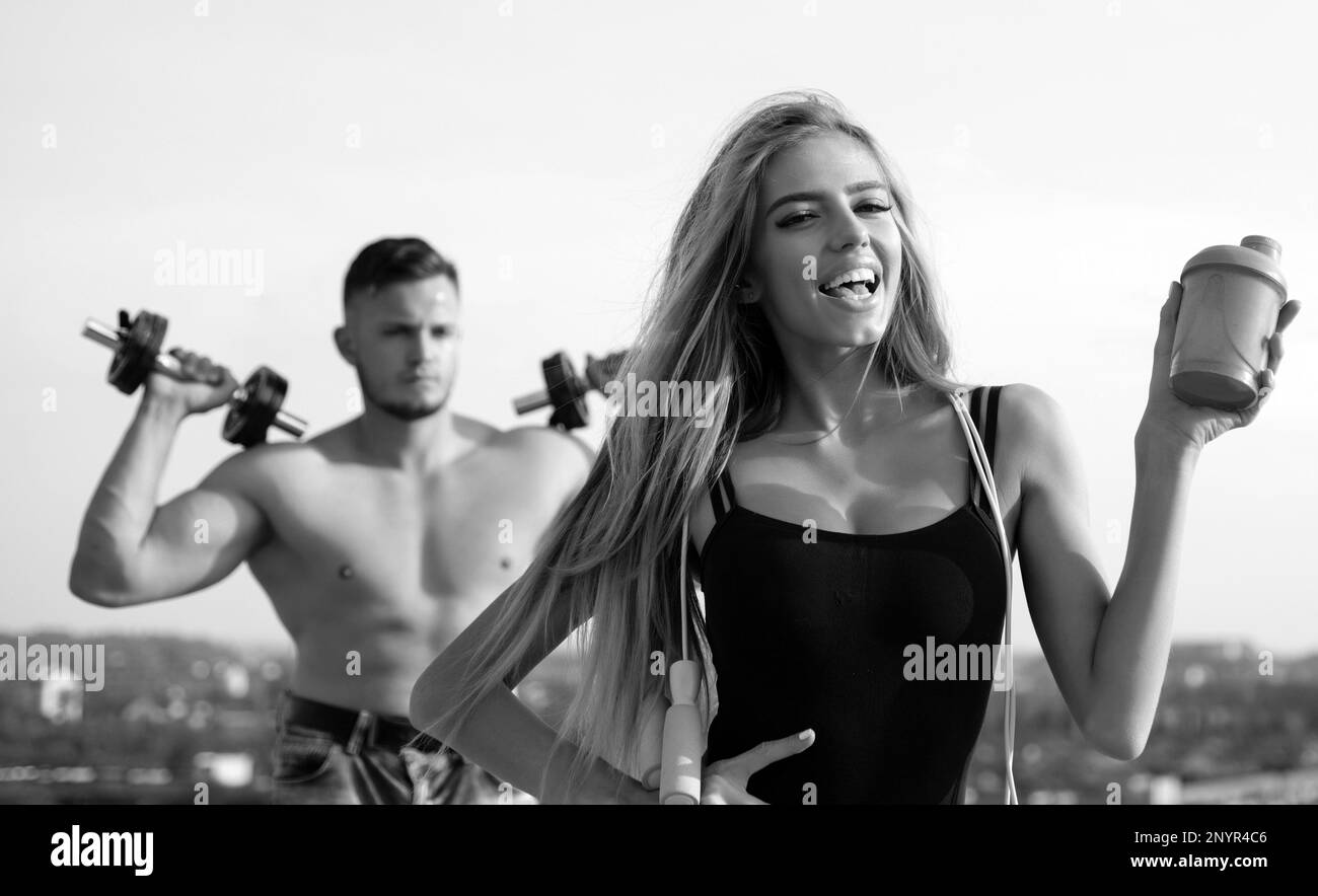 Female fitness coach with protein shaker. Man and girl with protein ...