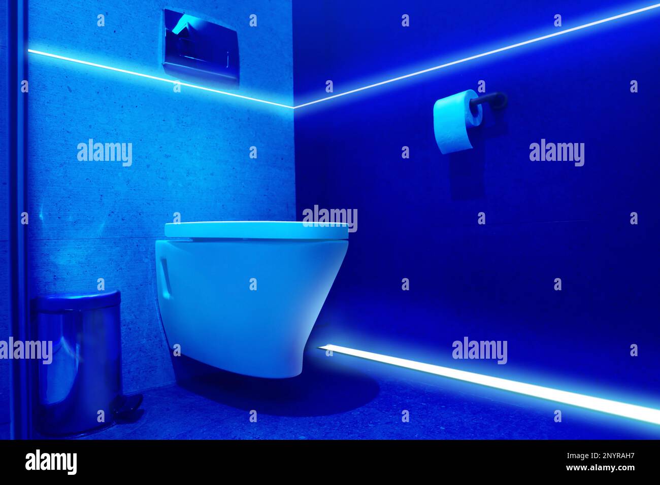 Toilet bowl in public restroom lit with UV blue light Stock Photo Alamy