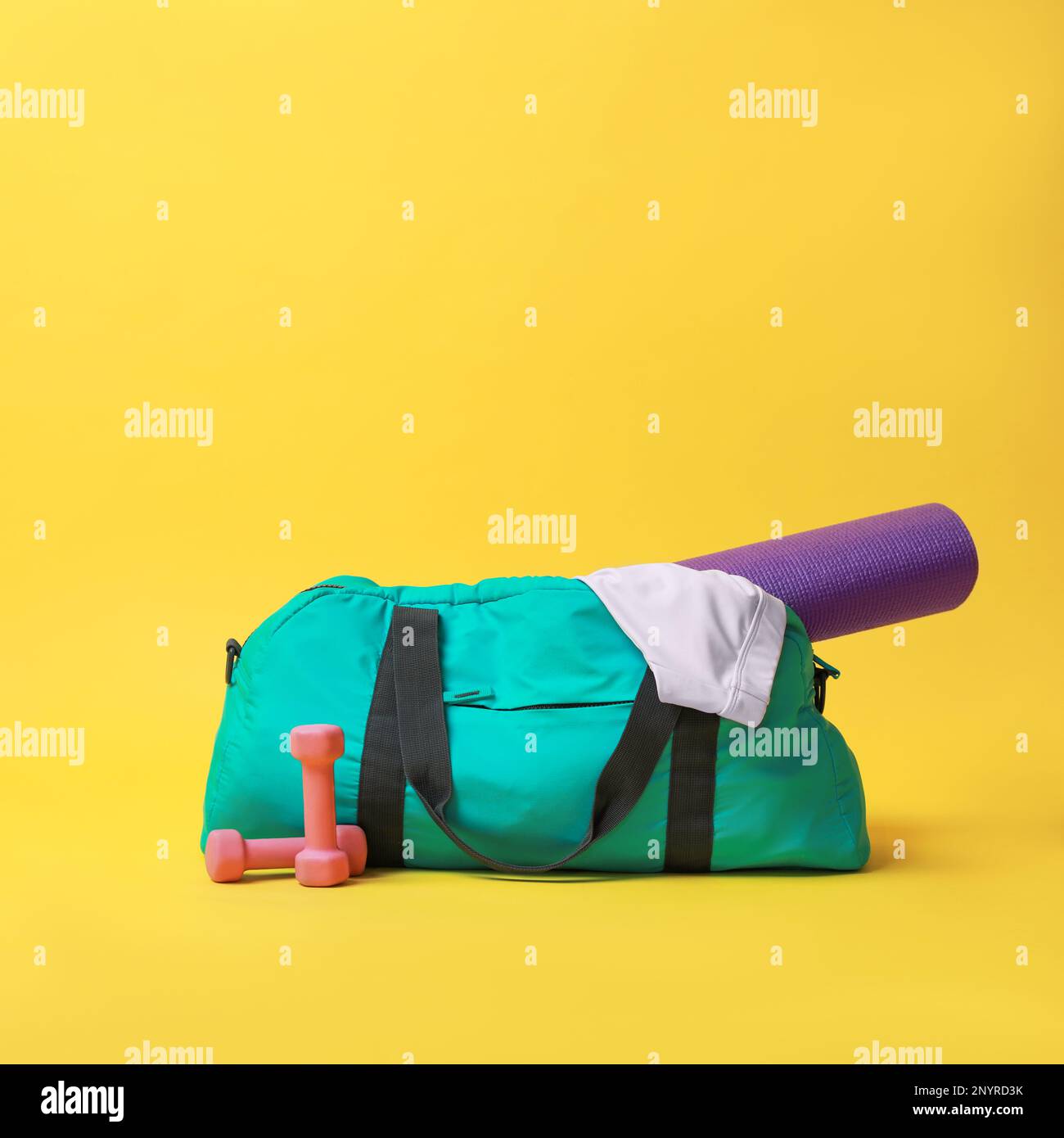 Blue gym bag and sports accessories on yellow background Stock Photo