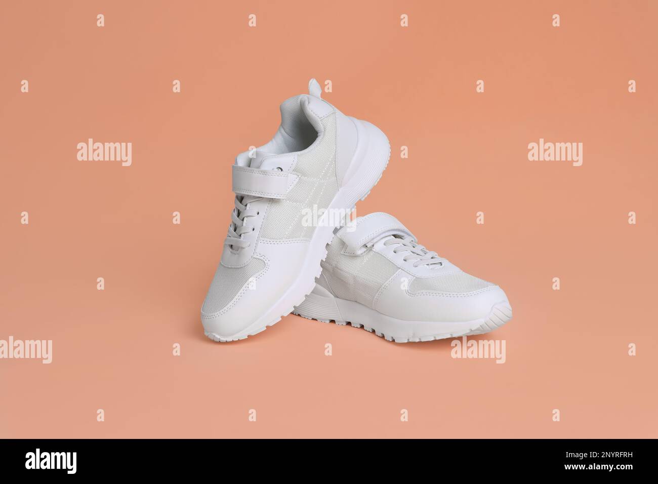 Pair of comfortable sports shoes on pale coral background Stock Photo ...