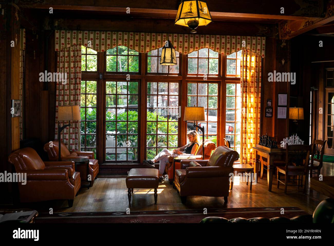 WA20981-00....WASHINGTON - Woman checking her phone in the loby of Lake Quinault Lodge. No MR. Stock Photo
