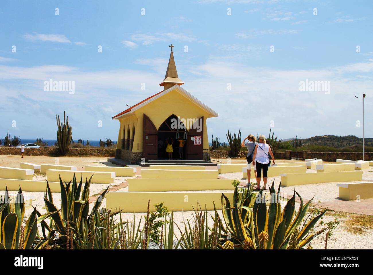 Alto Vista, Noord, Aruba - March 10, 2022. People walking between the outdoor pews toward the chapel, Alto Vista Chapel, Aruba. Stock Photo