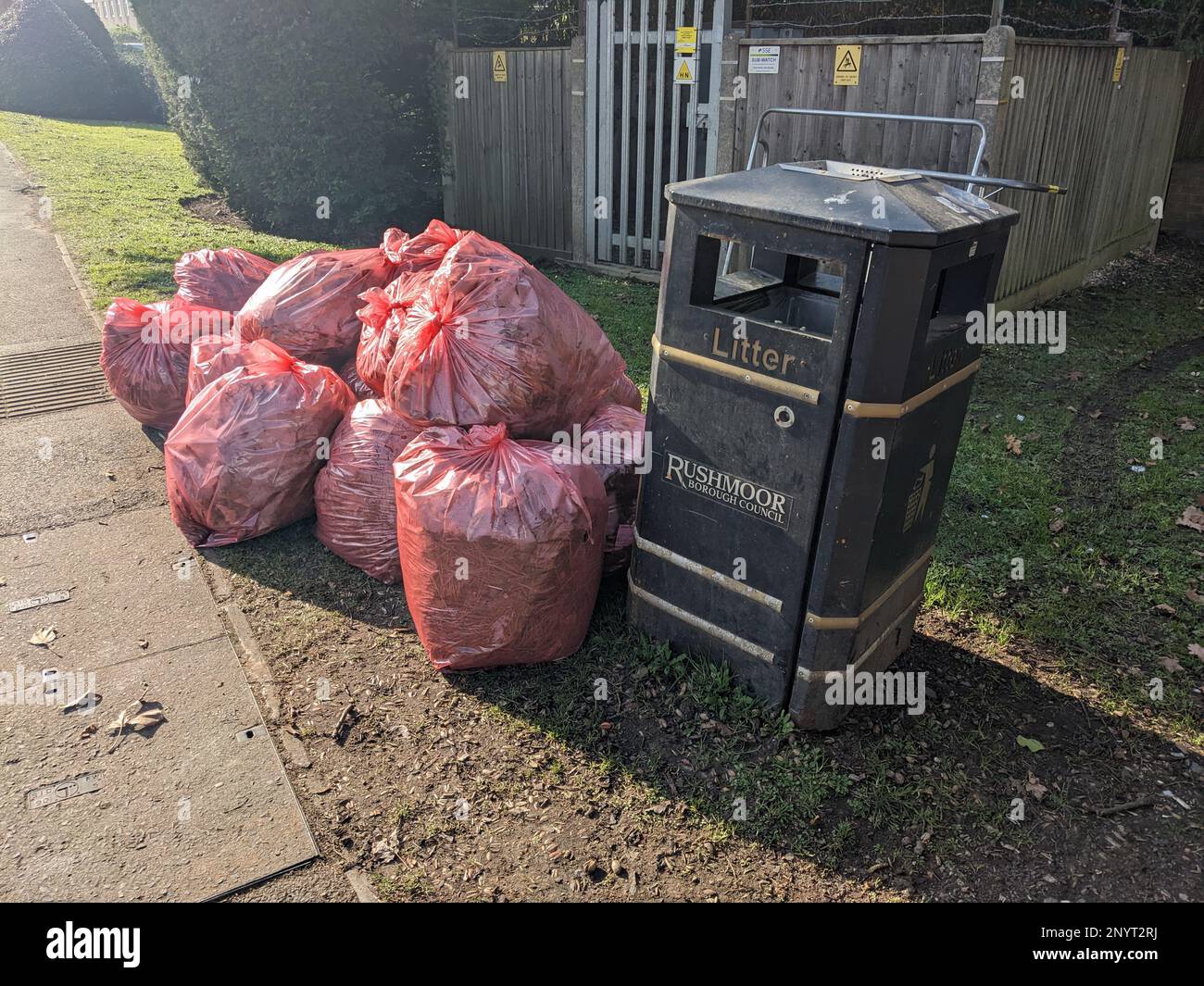 A Red Bin Bags Piling Up on A Street Corner Waiting to Be Collected