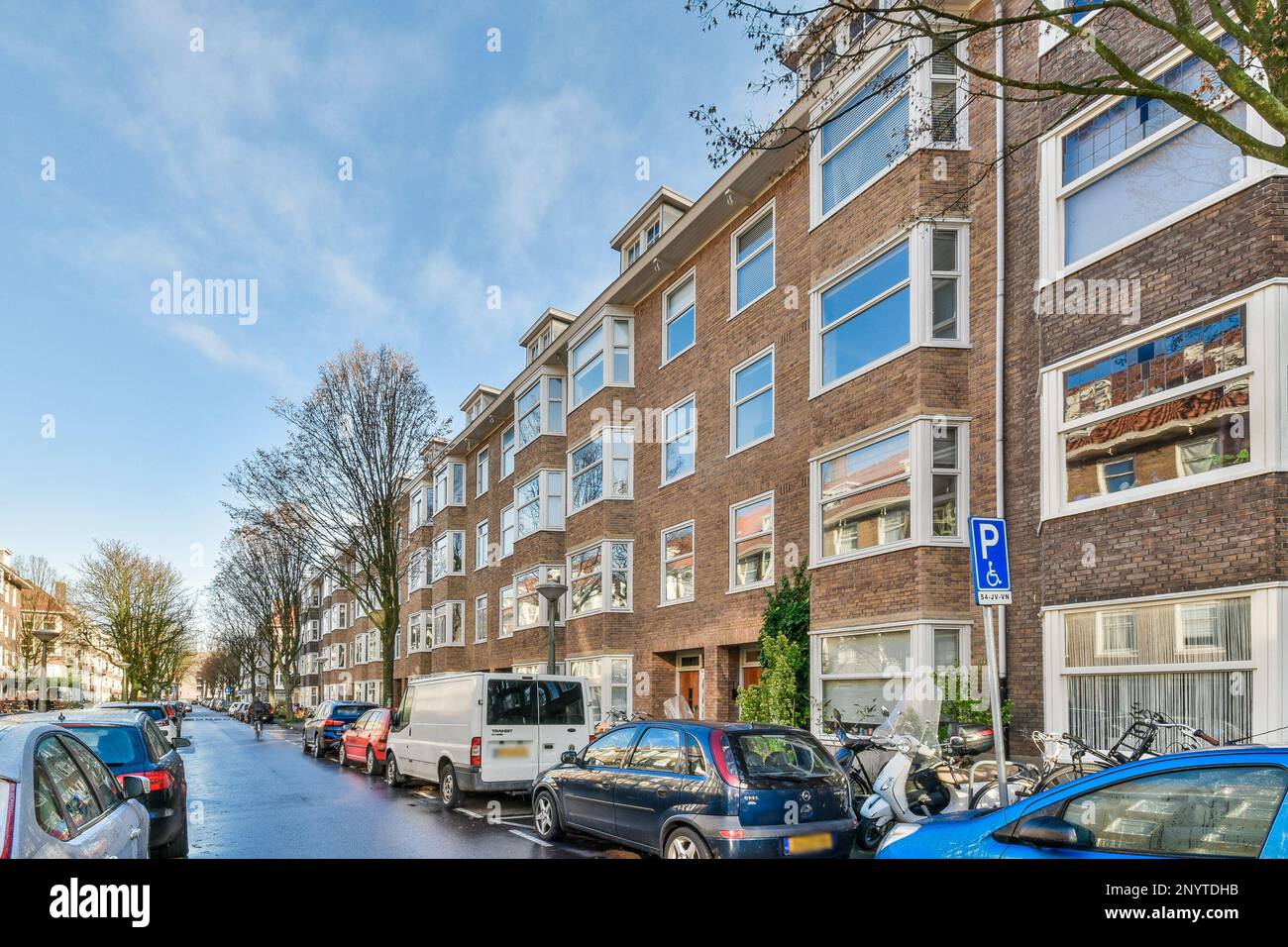 a street with cars parked on the side and buildings in the back ground ...