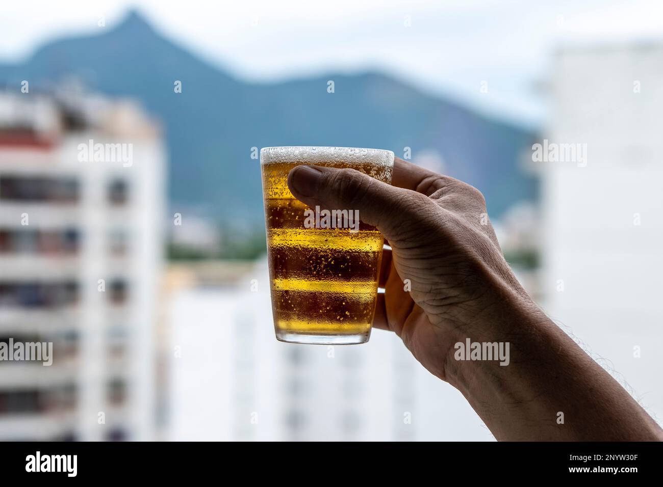 Happy Man Holding Drinking Glasses In The Kitchen High-Res Stock