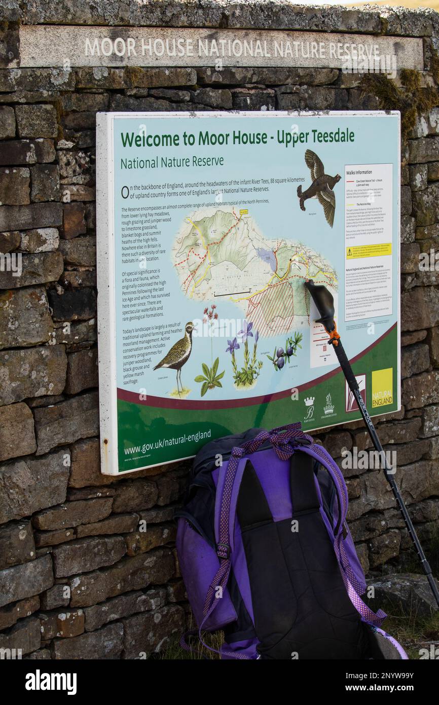 Rucksack and walking stick lean against noticeboard at Moor House National nature Reserve in Upper Teesdale, North Pennines AONB, Natural England. Stock Photo