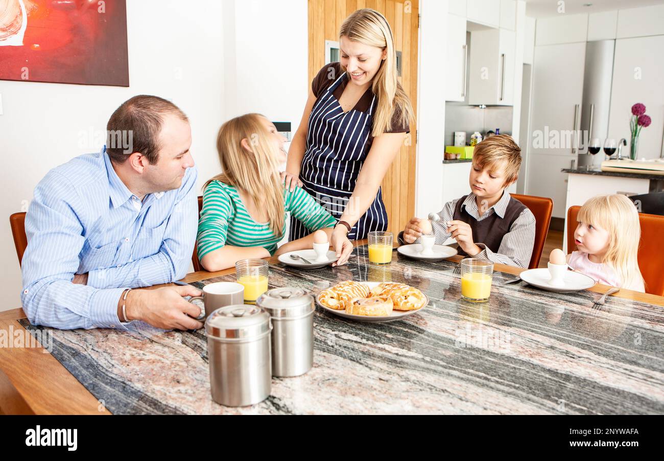 Family Life, Breakfast is Served. A young mother serving her family their morning meal. From a series of related images. Stock Photo